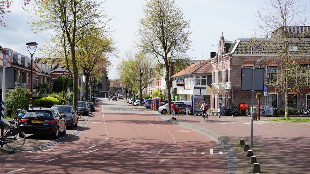 a street lined with parked cars next to tall buildings
