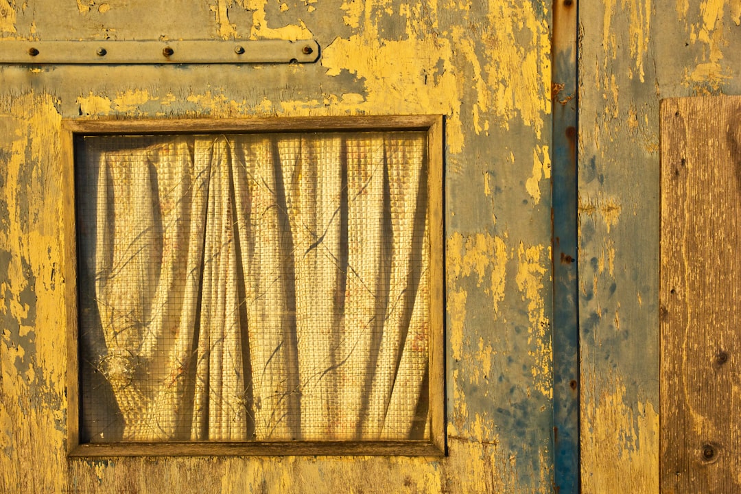 A yellow and blue building with a window