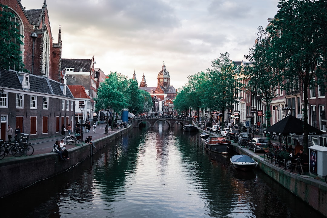 A canal runs through amsterdam, with buildings.