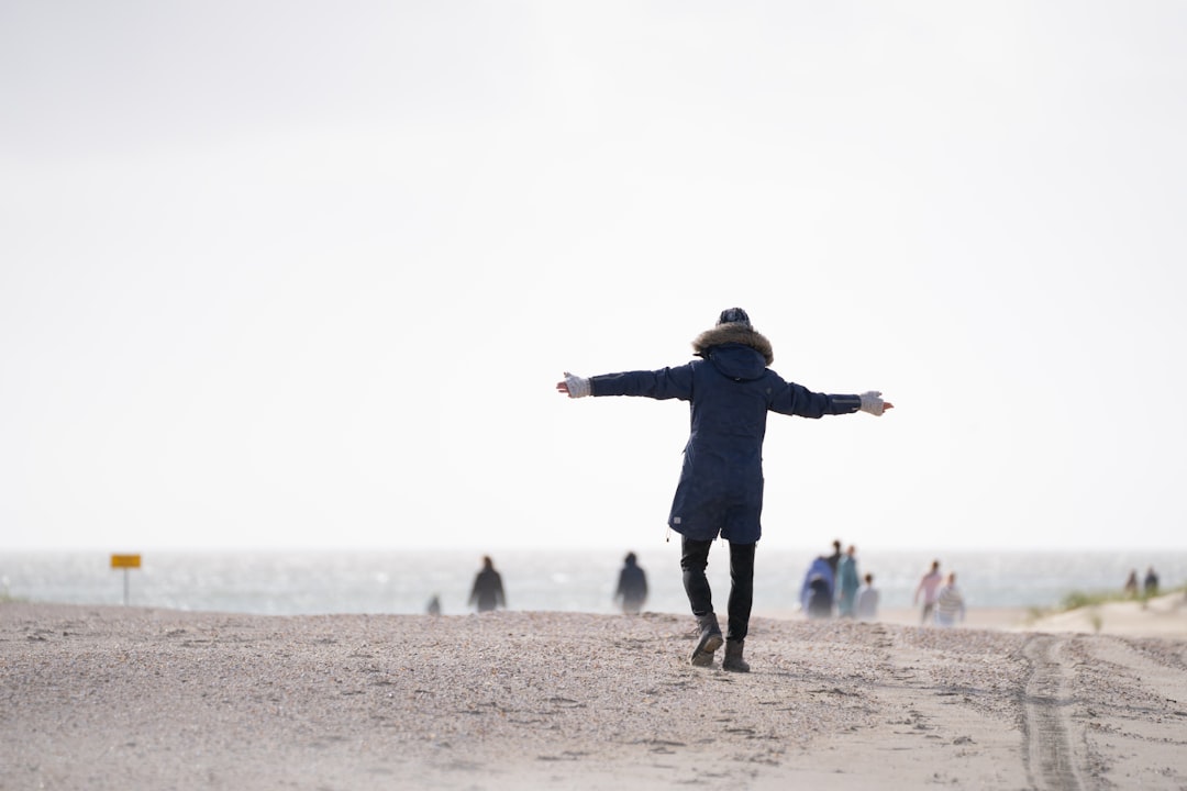 A person standing on a beach with their arms outstretched